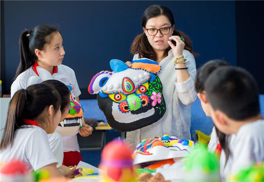 A teacher instructs students in making auspicious beast masks at the Nanchafang Primary School in Hohhot, Inner Mongolia autonomous region, on June 27, 2018. (Photo/Asianewsphoto)
Students from Nanchafang Primary School in Hohhot, Inner Mongolia autonomous region, learned to make a traditional auspicious beast mask under the guidance of teachers. They use super light clay to make a half-relief type lion mask, and got to know the cultural connotations of the craft, experiencing traditional culture directly.