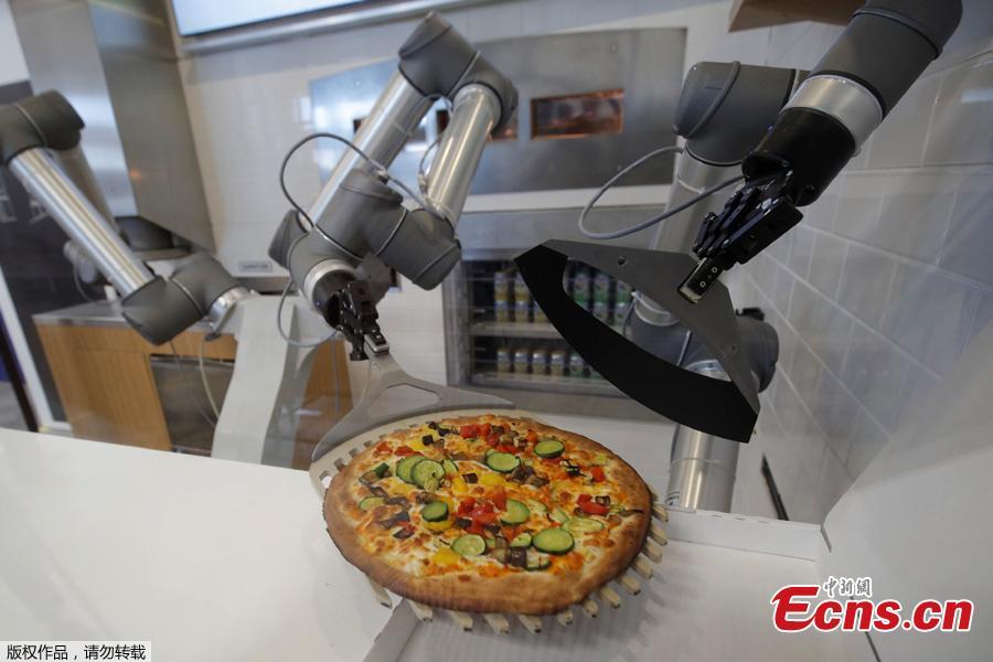 A pizzaiolo robot places a cooked pizza into its box before the customer’s eyes at the showroom of French food startup EKIM in Montevrain near Paris, France, June 26, 2018. Picture taken June 26, 2018. (Photo/Agencies)