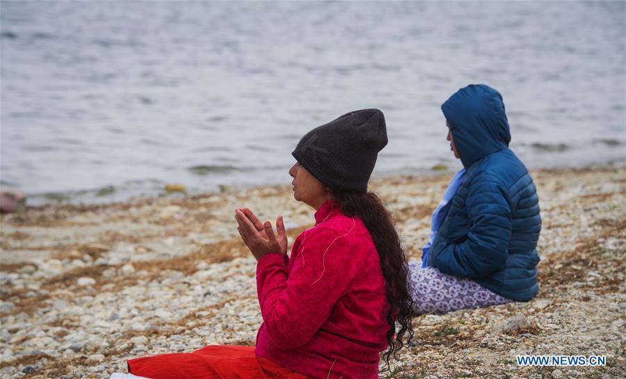 Indian pilgrims pray for blessing on the bank of Mapam Yumco Lake, a sacred Hindu and Buddhist site, in Ali Prefecture, southwest China\'s Tibet Autonomous Region, June 26, 2018. This year, the Nathu La Pass is expected to see about 500 officially-organized pilgrims from India who will make the 2,874-km pilgrimage, according to Yang Zhigang, deputy director of the office of foreign affairs and overseas Chinese affairs in Xigaze City. (Xinhua/Liu Dongjun)