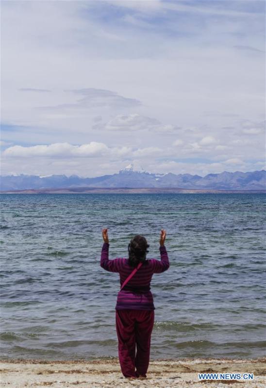An Indian pilgrim prays for blessing on the bank of Mapam Yumco Lake, a sacred Hindu and Buddhist site, in Ali Prefecture, southwest China\'s Tibet Autonomous Region, June 26, 2018. This year, the Nathu La Pass is expected to see about 500 officially-organized pilgrims from India who will make the 2,874-km pilgrimage, according to Yang Zhigang, deputy director of the office of foreign affairs and overseas Chinese affairs in Xigaze City. (Xinhua/Liu Dongjun)