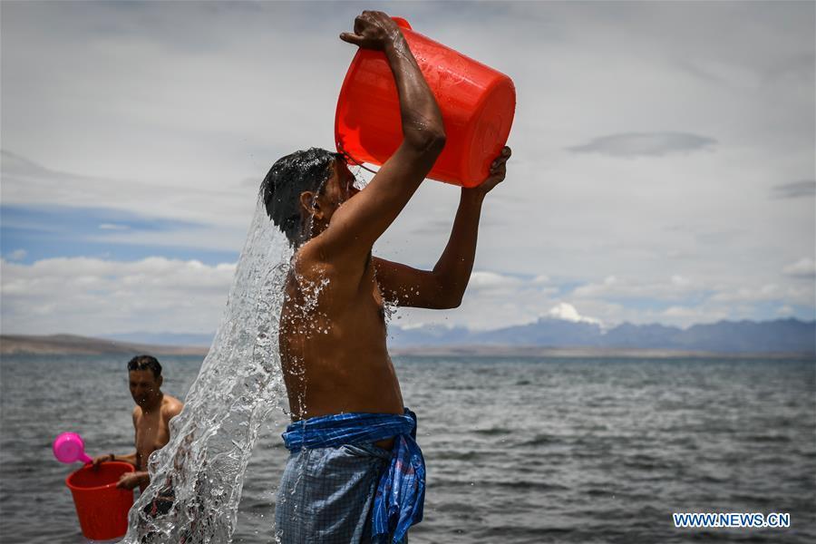 Indian pilgrims take a bath at Mapam Yumco Lake, a sacred Hindu and Buddhist site, in Ali Prefecture, southwest China\'s Tibet Autonomous Region, June 26, 2018. This year, the Nathu La Pass is expected to see about 500 officially-organized pilgrims from India who will make the 2,874-km pilgrimage, according to Yang Zhigang, deputy director of the office of foreign affairs and overseas Chinese affairs in Xigaze City. (Xinhua/Liu Dongjun)