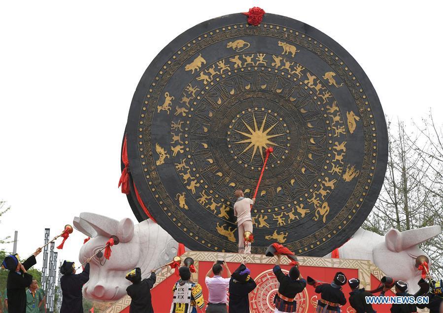 A guest beats a gigantic bronze drum during a celebration in Huanjiang Maonan Autonomous County, south China\'s Guangxi Zhuang Autonomous Region, June 29, 2018. The drum measures 6.68 meters in diameter and weighs 50 tons. It was recognized as the largest bronze drum by Guinness World Records. (Xinhua/Zhou Hua)