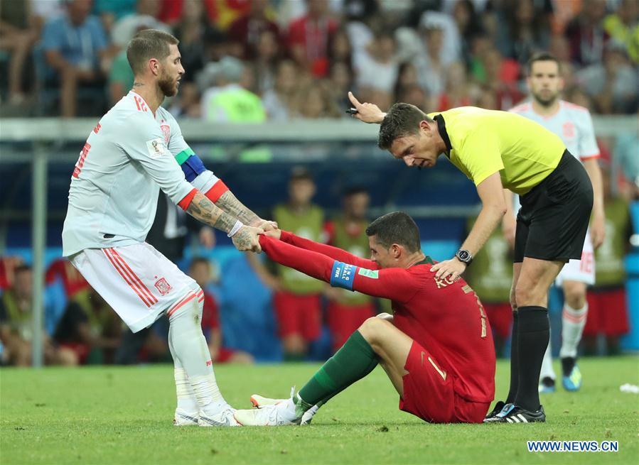 Sergio Ramos (L) of Spain tries to help Cristiano Ronaldo of Portugal during a group B match between Portugal and Spain at the 2018 FIFA World Cup in Sochi, Russia, June 15, 2018. The match ended in a 3-3 draw. (Xinhua/Ye Pingfan)
Best match
Spain and Portugal sent the World Cup off to a thrilling start with their 3-3 draw on the second day of the tournament in Sochi. Spain came from behind to take the lead via Nacho\'s superb long-range effort before Ronaldo\'s dramatic free-kick squared the ledger two minutes from time.