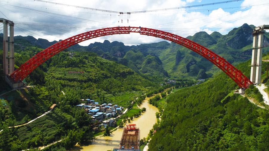 The last section is put into the position to finish the main span of the Daxiaojing Bridge in Guizhou Province, June 30, 2018. (Photo//chinadaily.com.cn)