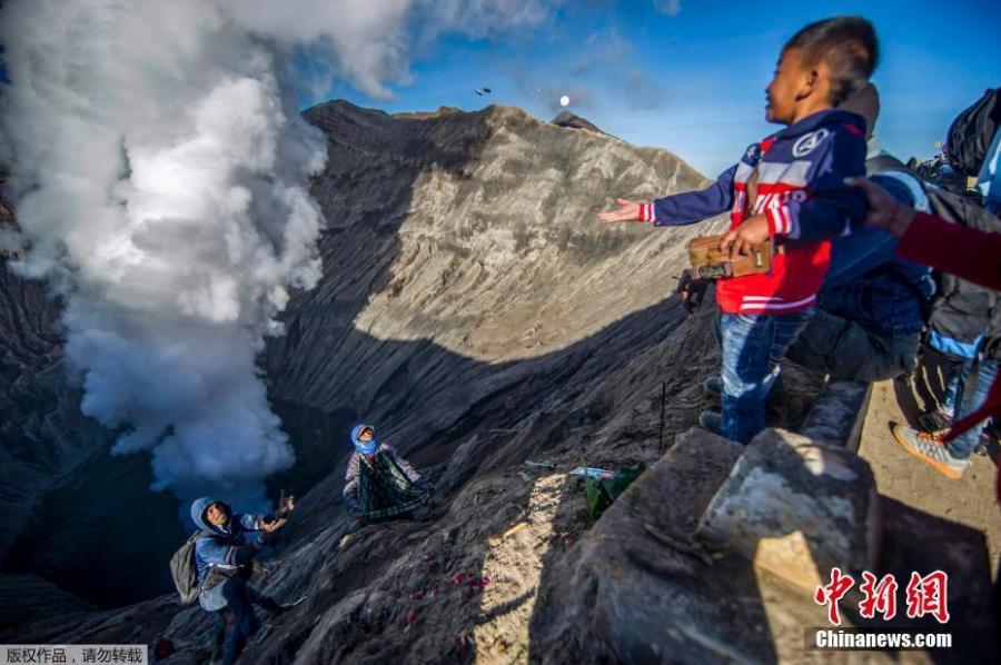 A Tengger tribe boy throws small change into the crater of Bromo volcano as an offering in Probolinggo, East Java province, June 30, 2018, as part of Yadnya Kasada festival which falls on the 14th day of the Kasada month based on the traditional Hindu lunar calendar. (Photo/Agencies)