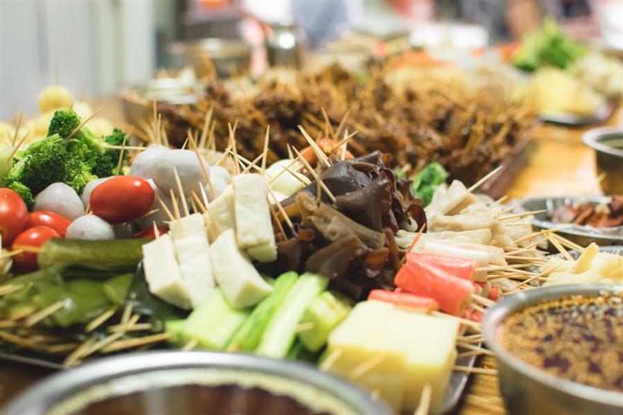 Lengzhanzhan is eaten by dipping the cooked ingredients on toothpicks in spicy sauce. (Photo/Shine.cn)
Lengzhanzhan
This is a new spicy snack from Mianyang that presents the vegetables and meats not on long bamboo skewers, but on toothpicks.
In principle, it’s similar to the cold chuanchuan dishes that soak skewers of cooked ingredients in chilled broth. Using toothpicks means everything is bite size, and each one costs from 30 to 50 cents.
When eating at a lengzhanzhan shop, each person is given a bowl to put the mini sticks of vegetables and meats as well as a dipping sauce on the side. The common options include potato, lotus root, corn, bean curd sheets, quail eggs, chicken heart and gizzard. When the meal is finished, the vendor would count the number of toothpicks left in the bowl to calculate the bill.
For people who are not into spicy cuisine, non-spicy sauce is also available.