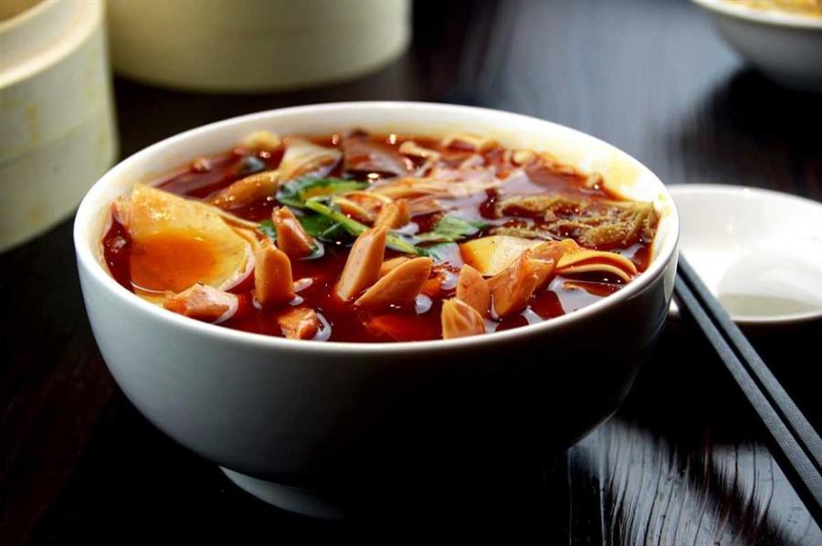 “Maocai is one man\'s hotpot, and hotpot is maocai for a group of people.” (Photo/Shine.cn)
Maocai
Maocai is the third Sichuan dish that took the country by storm after hotpot and malatang. There’s a popular saying that “maocai is one man’s hotpot, and hotpot is maocai for a group of people.”
Basically, maocai is a bowl of spicy vegetable and meat stew, and it’s much simpler than hotpot and even malatang — you don’t have to pick the ingredients from the shelves or cook them in the broth yourself, the restaurant will do all the work.
The character mao here is a verb that means cooking the ingredients. The ingredients are first boiled in a spicy broth and a bowl on the side already has different seasonings in place. Once cooked, the meats and vegetables are poured into the bowl along with a large spoonful of spicy broth. Top the bowl with cilantro, scallion and Sichuan-style fermented bean paste and the dish is ready to serve.
Maocai can be eaten with a bowl of rice as a dish or alone as a meal. Another difference that sets maocai and hotpot or chuanchuanxiang apart is that the broth is edible as it contains much less oil.
Popular ingredients in maocai include duck intestine, beef tripe, beencurd sheets, tofu, bok choy and duck blood tofu. If you don’t want to order every ingredient, most of the maocai shops offer combo meals that include a little bit of everything.