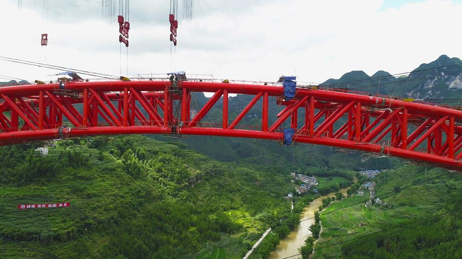 The last section is put into the position to finish the main span of the Daxiaojing Bridge in Guizhou Province, June 30, 2018. (Photo//chinadaily.com.cn)