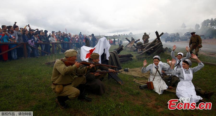 Military enthusiasts take part in a re-enactment of a World War II battle on the eve of Independence Day at the \
