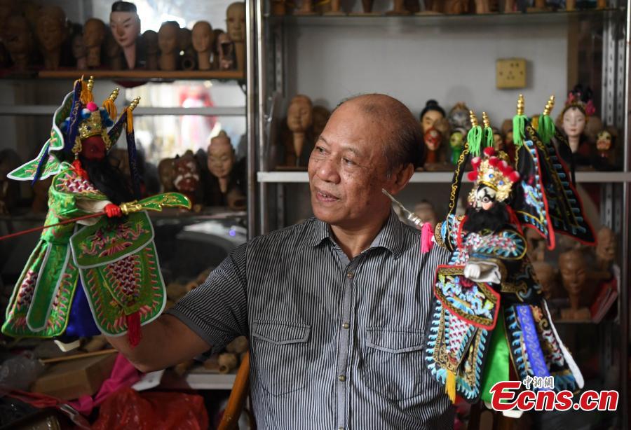 Folk artist Yang Yazhou shows his puppet head creations in his studio in Zhangzhou City, East China’s Fujian Province, July 1, 2018. Zhangzhou has a history of puppetry going back more than two thousand years. Yang represents the fifth generation of his family to be involved with Fuchun-style glove puppets show, an intangible cultural heritage. He began learning to carve puppet heads when he was nine years old, taught by several masters. Yang said it takes tens of steps to finish carving a puppet-head in about three days. Yang’s sister specializes in dressing the puppets, his brother in puppet performance. (Photo: China News Service/Zhang Bin)