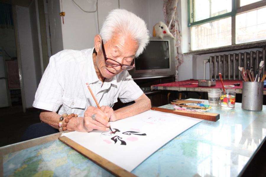 Zhang Fuli, 85, draws a facial mask of Peking Opera at home in Zhangjiakou, North China\'s Hebei Province.(Photo//chinadaily.com.cn)
An 85-year-old man in Zhangjiakou, North China\'s Hebei Province has been painting Peking Opera facial masks for more than 50 years. Zhang Fuli used to be a professional performer of wusheng (a male martial-arts role in Peking Opera) when he was young. Based on his love for operas, Zhang draws facial masks as an amateur and has made more than 700 masks.