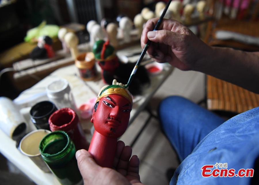 Folk artist Yang Yazhou paints the head of a puppet in his studio in Zhangzhou City, East China’s Fujian Province, July 1, 2018. Zhangzhou has a history of puppetry going back more than two thousand years. Yang represents the fifth generation of his family to be involved with Fuchun-style glove puppets show, an intangible cultural heritage. He began learning to carve puppet heads when he was nine years old, taught by several masters. Yang said it takes tens of steps to finish carving a puppet-head in about three days. Yang’s sister specializes in dressing the puppets, his brother in puppet performance. (Photo: China News Service/Zhang Bin)