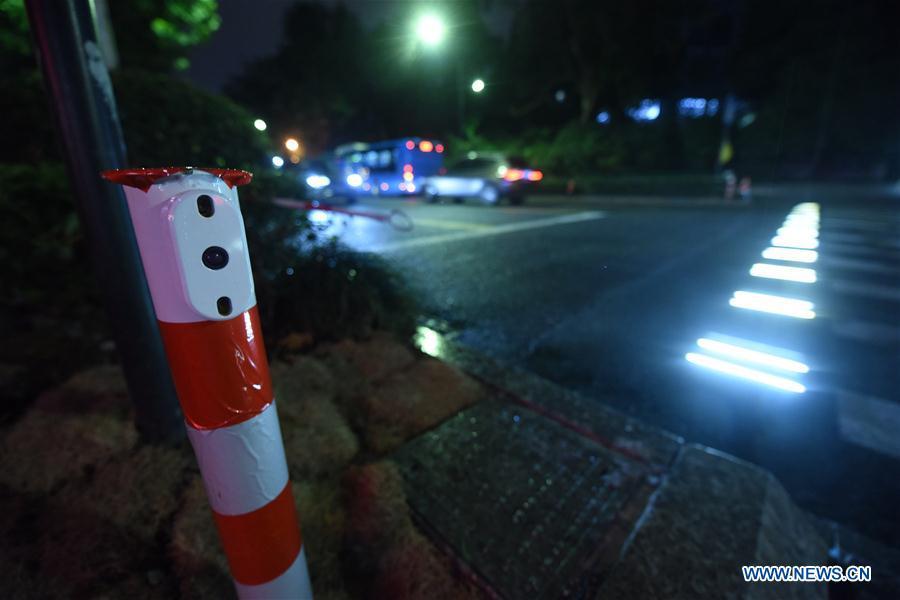 A lighted pedestrian crossing is seen on Xixi Road in Hangzhou, capital of east China\'s Zhejiang Province, July 2, 2018. Lamps installed along the pedestrian crossing light up at night, giving directions to pedestrians and vehicles. (Xinhua/Long Wei)
