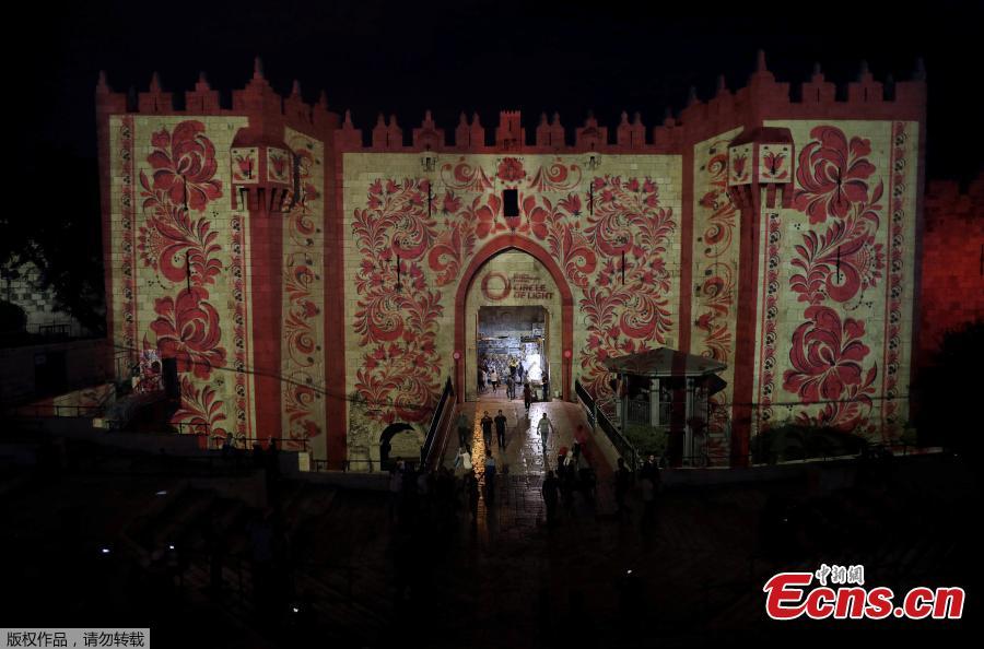 People stand near Damascus Gate outside Jerusalem\'s Old City as it is projected with images during the annual Light Festival, June 28, 2018. (Photo/Agencies)