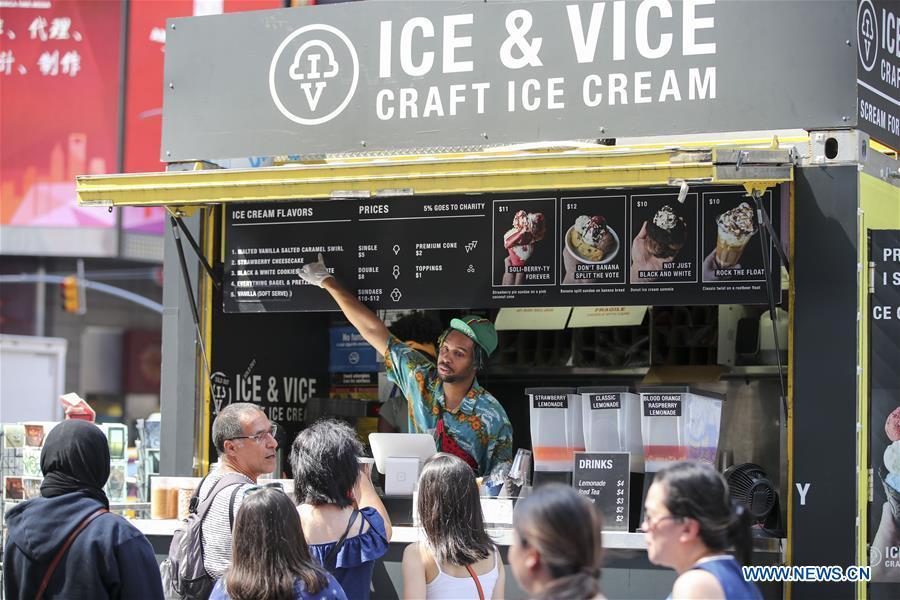 People queue to buy ice cream at Times Square in New York City, the United States, on July 2, 2018. The highest temperature reached 35 degrees Celsius in New York City on Monday as a result of a prolonged heat wave. (Xinhua/Wang Ying)