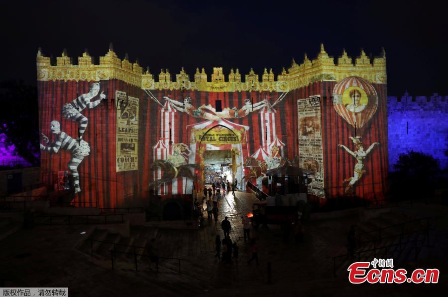 People stand near Damascus Gate outside Jerusalem\'s Old City as it is projected with images during the annual Light Festival, June 28, 2018. (Photo/Agencies)