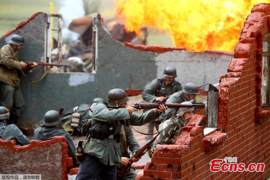 Military enthusiasts take part in a re-enactment of a World War II battle on the eve of Independence Day at the \
