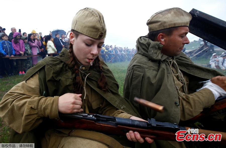 Military enthusiasts take part in a re-enactment of a World War II battle on the eve of Independence Day at the \
