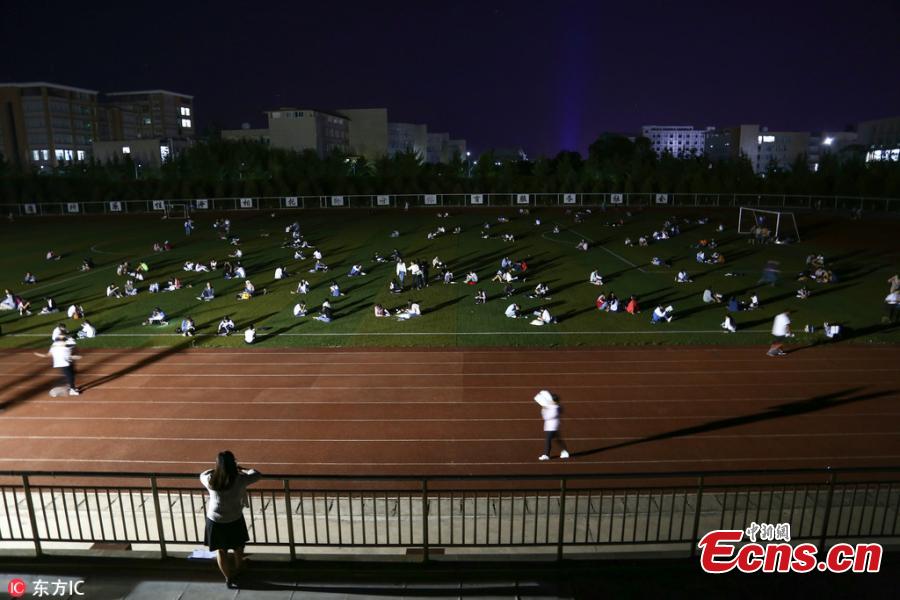 Students prepare for semester final exams on the football field of Qujing Medical College in Southwest China’s Yunnan Province, July 4, 2018. Students used flashlights on their mobile phones, small chargeable table lamps, and the lights of the football field to help them revise outside on what was a hot summer night. (Photo/IC)