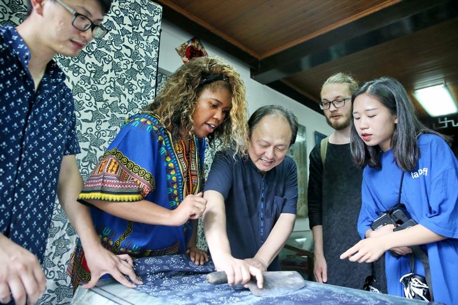 Chinese and British students from the China Academy of Art\'s creative fashion design camp observe traditional printing and dyeing of Chinese blue calico in Nantong, East China\'s Jiangsu Province, on July 3, 2018. (Photo/Asianewsphoto)