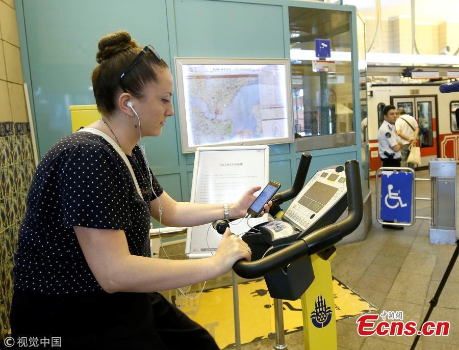 A woman uses a bicycle pedal power generator which was installed by the IETT (Istanbul electric tramway and tunnel establishments) at the Tunnel railway station to charge her mobile phone in Istanbul, Turkey, July 05, 2018. (Photo/Agencies)