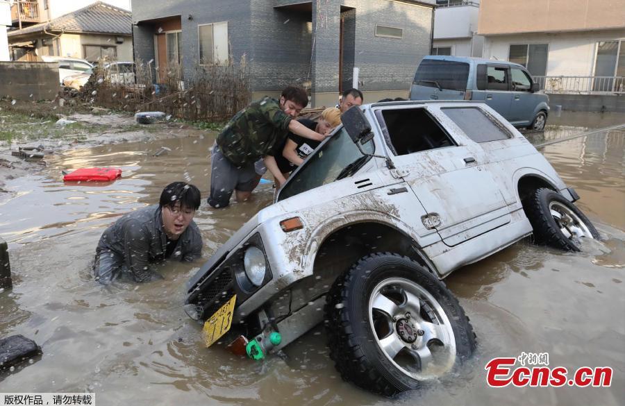 Residents try to upright a vehicle stuck in a flood hit area in Kurashiki, Okayama prefecture on July 9, 2018. The death toll from widespread flooding and landslides rose to 126, according to Japanese authorities. (Photo/Agencies)