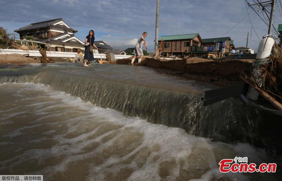 Residents cross an area still flooded in Kurashiki, Okayama prefecture on July 9, 2018.
The death toll from widespread flooding and landslides rose to 126, according to Japanese authorities. (Photo/Agencies)