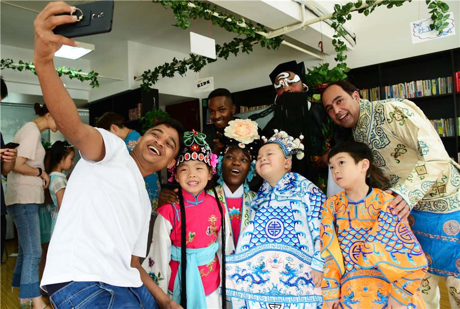 Foreign students pose for a selfie with children in Zhenjiang city, Jiangsu Province, on July 9, 2018. (Photo/Asianewsphoto)