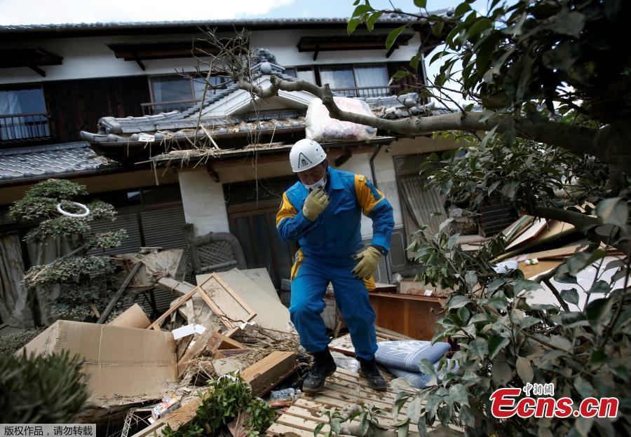 A police officer checks a submerged and destroyed house in a flood affected area in Mabi town in Kurashiki, Okayama Prefecture, Japan, July 10, 2018.The death toll from widespread flooding and landslides rose to 126, according to Japanese authorities. (Photo/Agencies)