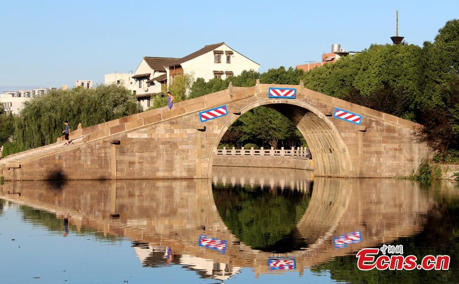 A view of the newly opened Huanxi Yongning Bridge in Hangzhou, Zhejiang Province, July 13, 2018. A part of the ancient stone arch bridge, built in 1770, collapsed due to heavy rain on July 6 and reconstruction has now been completed. (Photo: China News Service/Zhu Zi)