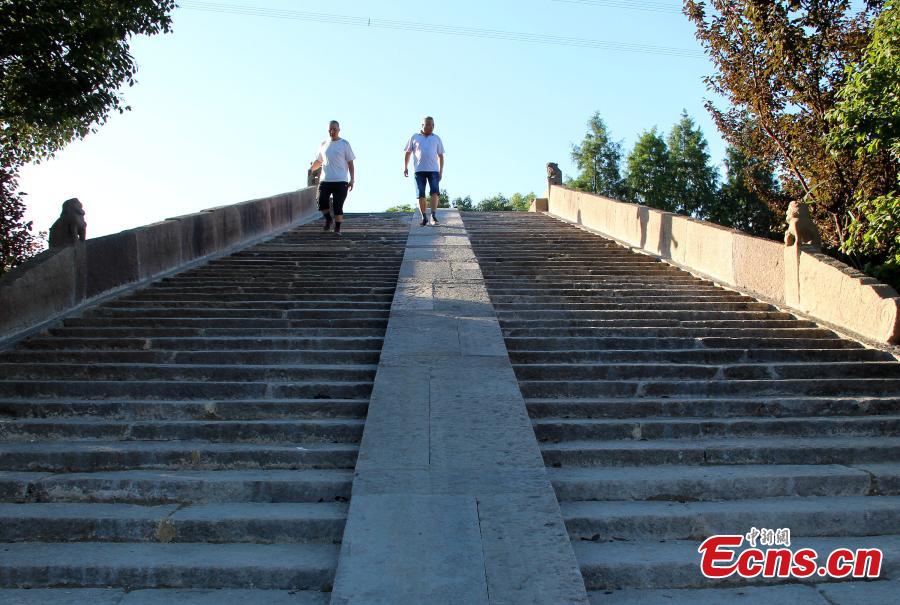 A view of the newly opened Huanxi Yongning Bridge in Hangzhou, Zhejiang Province, July 13, 2018. A part of the ancient stone arch bridge, built in 1770, collapsed due to heavy rain on July 6 and reconstruction has now been completed. (Photo: China News Service/Zhu Zi)