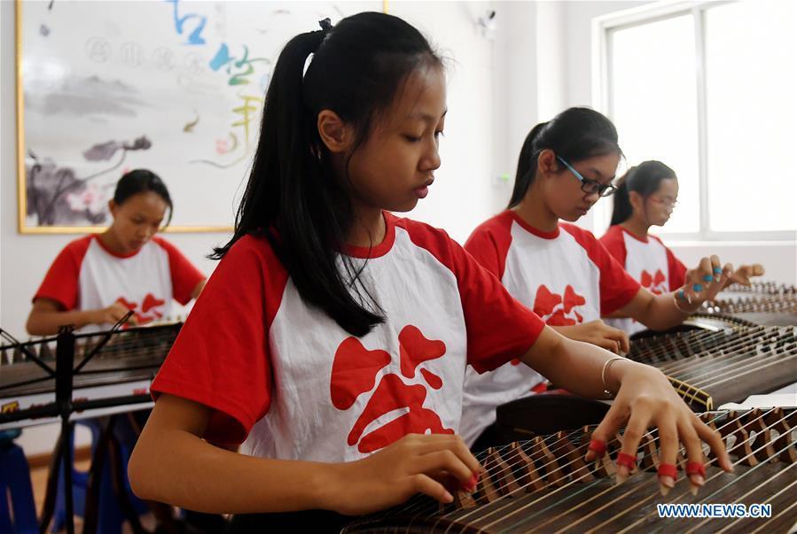 Students learn playing zither during a class in Qinzhou City, south China\'s Guangxi Zhuang Autonomous Region, July 12, 2018. Students learn new skills during their summer vacation. (Xinhua/Zhang Ailin)