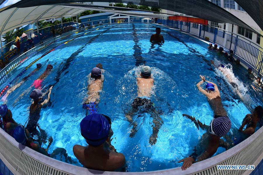 Students of a local primary school attend a swimming class during summer vacation in Qionghai, south China\'s Hainan Province, July 12, 2018. (Xinhua/Meng Zhongde)