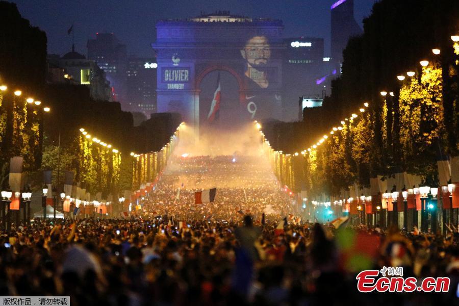 A giant picture of France\'s Antoine Griezmann is seen on the Arc de Triomphe as France fans celebrate on the Champs-Elysees Avenue after France won the Soccer World Cup final, July 15, 2018. (Photo/Agencies)