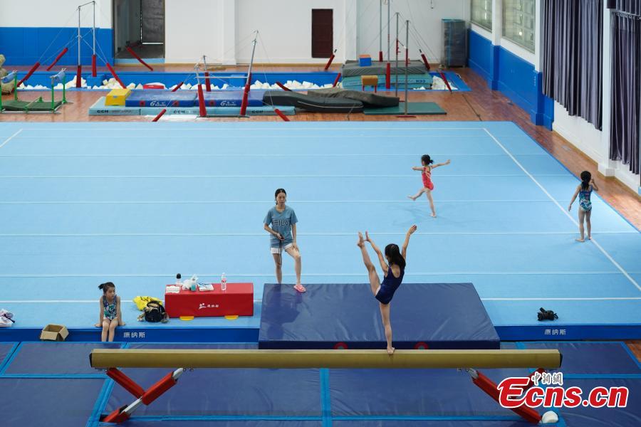 Students train at the Amateur Children\'s Gymnastics Training School in Rongjiang County, Southwest China’s Guizhou Province, July 16, 2018. There are 60 children taking part in gymnastics training at the school during their spare time. Since 1972, the county has sent 21 athletes to the provincial gymnastics and gymnastics trampoline teams, among whom six later became national team members. The county is home to Liu Rongbing, who won a gold medal for the men\'s team in the 2014 World Artistic Gymnastics Championships. (Photo: China News Service/He Junyi)
