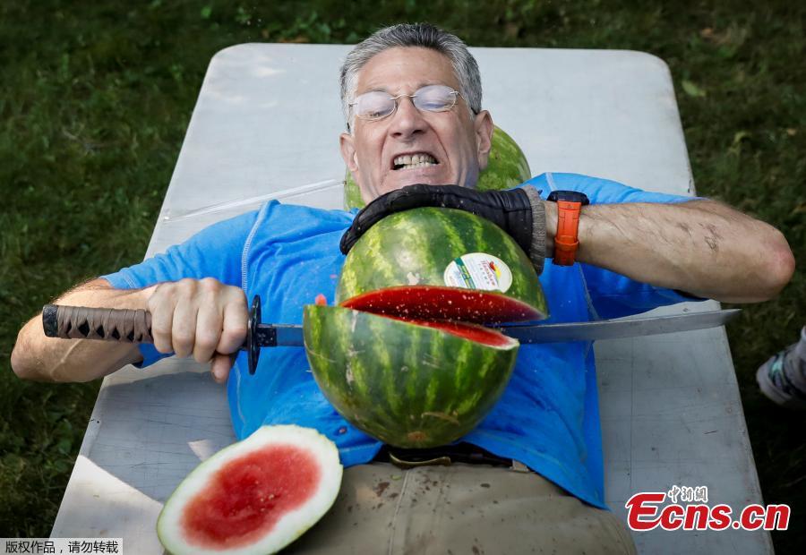 Ashrita Furman, who holds more Guinness World Records than anyone, attempts to set a new record for slicing the most watermelons in half on his own stomach in one minute in New York City, U.S., July 17, 2018. (Photo/Agencies)