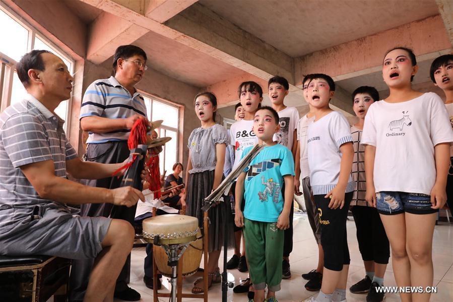 Students from a primary school learn opera under the guidance of teachers in Shijiazhuang, north China\'s Hebei Province, July 18, 2018. Chinese students have entered their summer vacation, during which many of them chose to spend the vacation by developing their hobbies. (Xinhua/Liang Zidong)