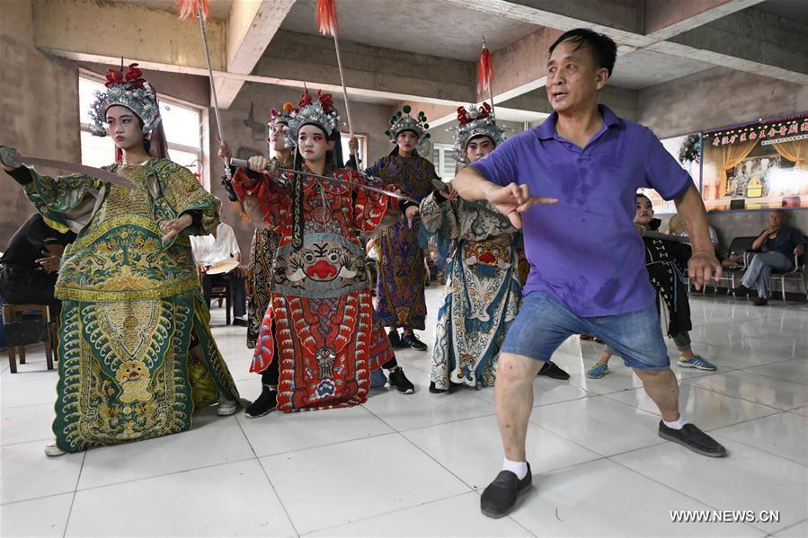 Students from a primary school learn opera movements under the guidance of a teacher in Shijiazhuang, north China\'s Hebei Province, July 18, 2018. Chinese students have entered their summer vacation, during which many of them chose to spend the vacation by developing their hobbies. (Xinhua/Chen Qibao)