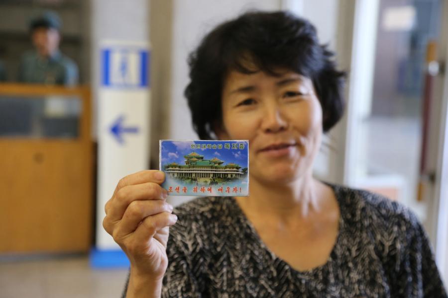 A reader shows her library card to reporters from Xinhua in the Grand People\'s Study House, Pyongyang, DPRK, on July 17, 2018. (Photo/Xinhua)