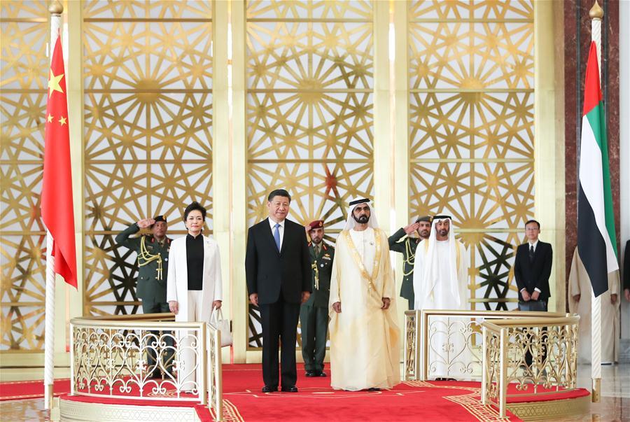 Chinese President Xi Jinping, his wife Peng Liyuan and the United Arab Emirates (UAE) Vice President and Prime Minister Sheikh Mohammed bin Rashid Al Maktoum are seen on a reviewing stand in Abu Dhabi, the UAE, July 19, 2018. Xi arrived here on Thursday for a state visit to the UAE. The UAE\'s vice president hosted a welcome ceremony for the Chinese president at the airport. (Xinhua/Xie Huanchi)