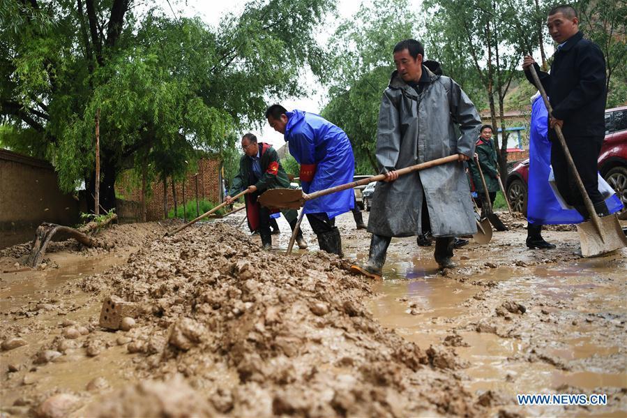 People clear the mud at flood-hit Chenhe Village of Dongxiang Autonomous County in Linxia Hui Autonomous Prefecture, northwest China\'s Gansu Province, July 20, 2018. About 1.08 million people in Gansu Province were affected by rain-triggered floods, with 12 deaths, four people missing and 27,000 people evacuated. (Xinhua/Chen Bin)