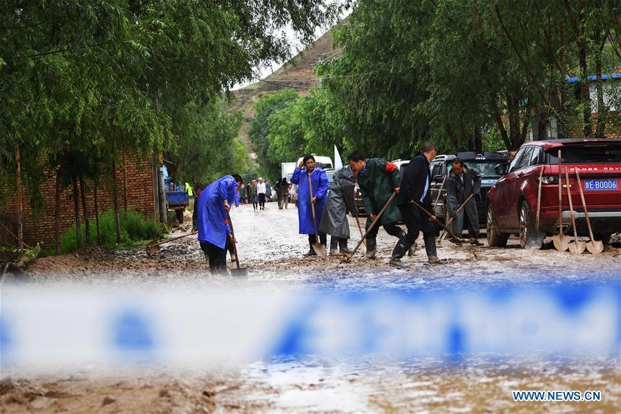 People clear the mud at flood-hit Chenhe Village of Dongxiang Autonomous County in Linxia Hui Autonomous Prefecture, northwest China\'s Gansu Province, July 20, 2018. About 1.08 million people in Gansu Province were affected by rain-triggered floods, with 12 deaths, four people missing and 27,000 people evacuated. (Xinhua/Chen Bin)