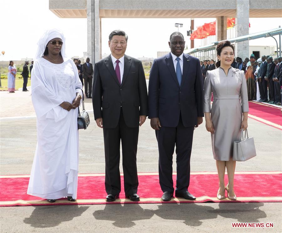 Chinese President Xi Jinping and his wife Peng Liyuan pose for a group photo with Senegalese President Macky Sall and his wife Marieme after Xi and Sall inspected the guard of honor at the airport in Dakar, Senegal, July 21, 2018. Xi arrived here Saturday for a state visit to Senegal. Sall held a grand welcome ceremony in Xi\'s honor. (Xinhua/Wang Ye)