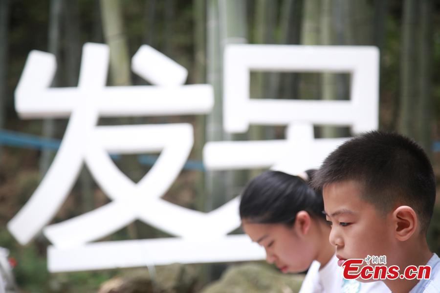 Blank-faced contestants, including children, sit still and do nothing in a “space-out” contest in Hangzhou City, the capital of East China’s Zhejiang Province, July 21, 2018. Some 100 residents attended the contest, enjoying a moment or two of relaxation. (Photo: China News Service/Liu Peiqi)