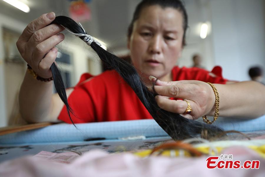 A woman creates a hair embroidery work in Dongtai, Yancheng City of Jiangsu Province, July 22, 2018. Hair embroidery refers to a style of embroidery that uses human hair as thread instead of other materials. According to historical records, hair embroidery originated in Dongtai more than 1,300 years ago. Hair embroidery designs are vivid and varied, involving living creatures, plants, landscapes and historical figures. The art is now included in the provincial-level intangible cultural heritage list. (Photo: China News Service/Yang Bo)