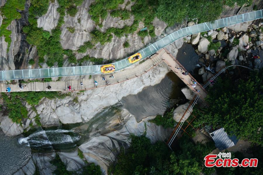 An aerial view of a waterslide over the Xiangma River in Lushan County, Central China’s Henan Province, July 23, 2018. The 2.3-kilometer-long waterslide around a mountain slope and cliff has a vertical drop of 100 meters, earning it the title of the longest and most challenging waterslide in central China. The thrilling project opened on Monday. (Photo: China News Service/Dong Fei)