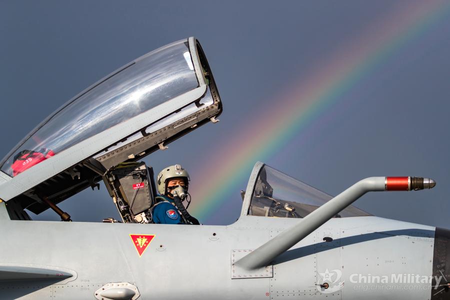 A pilot assigned to the Chinese PLA Air Force sits in the cockpit of his J-10A fighter jet as a rainbow appears in the sky on July 21. All aircraft of the PLA Air Force to participate in the \