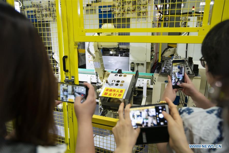 People visit an intelligent plant of Wanxiang Qianchao Co., Ltd. in east China\'s Zhejiang Province, July 4, 2018. This year marks the 40th anniversary of China\'s reform and opening-up policy. (Xinhua/Shen Bohan)