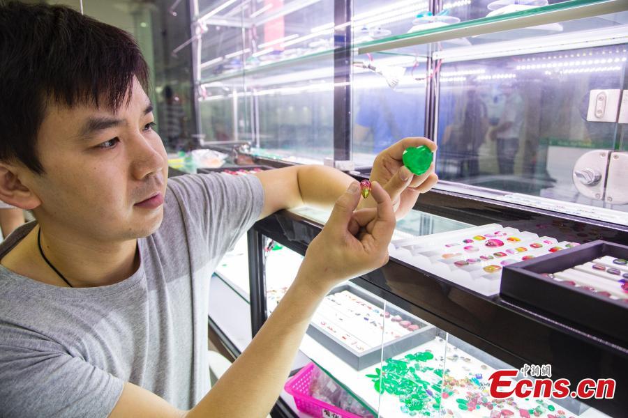 Jian Guoxiong, a gemstone businessman, shows an artificial gem in a jewelry store in Wuzhou City, South China’s Guangxi Zhuang Autonomous Region, July 24, 2018. They need to select at least 20,000 qualified pieces from more than 100,000 gemstones a day. Wuzhou is widely held to be the world capital for artificial gems and a trading center that now serves China and the rest of the world. Since the first factory was established there in 1982, Wuzhou now boasts an annual production value for the industry of approximately 3.2 billion yuan ($470 million). (Photo: China News Service/Chen Guanyan)
