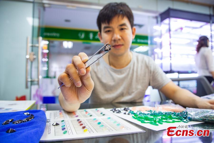 Jian Guoxiong, a gemstone businessman, shows an artificial gem in a jewelry store in Wuzhou City, South China’s Guangxi Zhuang Autonomous Region, July 24, 2018. They need to select at least 20,000 qualified pieces from more than 100,000 gemstones a day. Wuzhou is widely held to be the world capital for artificial gems and a trading center that now serves China and the rest of the world. Since the first factory was established there in 1982, Wuzhou now boasts an annual production value for the industry of approximately 3.2 billion yuan ($470 million). (Photo: China News Service/Chen Guanyan)
